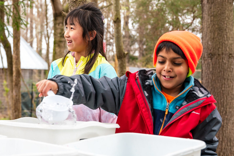 two campers scooping water for the birds