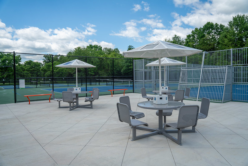 solar picnic tables next to tennis and soccer court