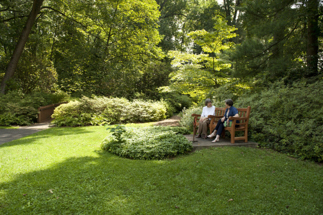 visitors on a bench at McCrillis House and Gardens