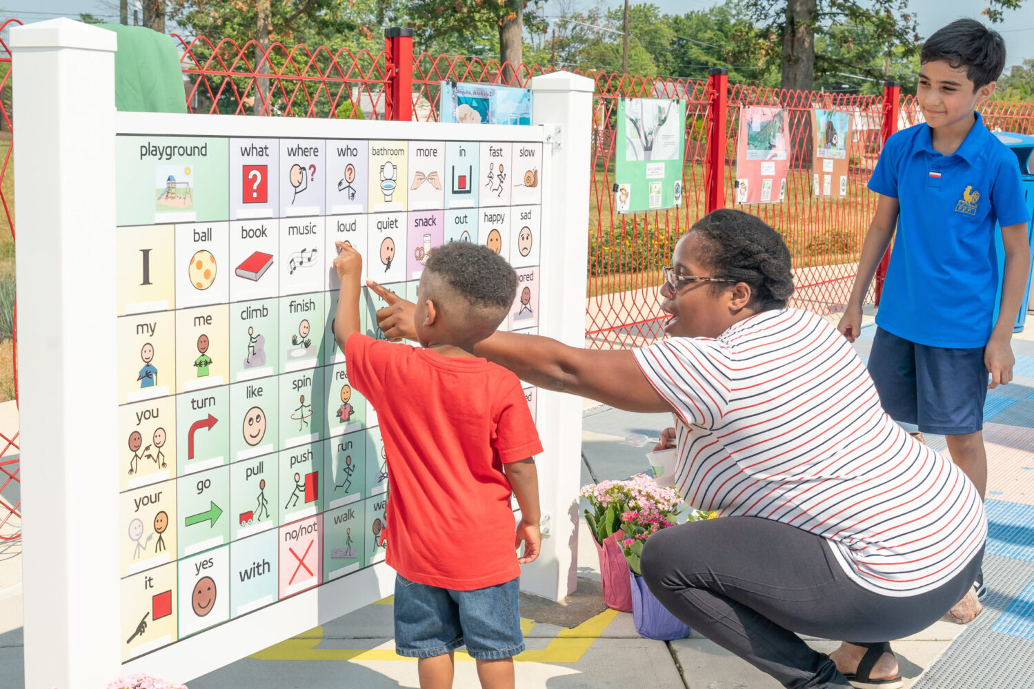 Adult and children pointing at a communication board Wheaton Local Park