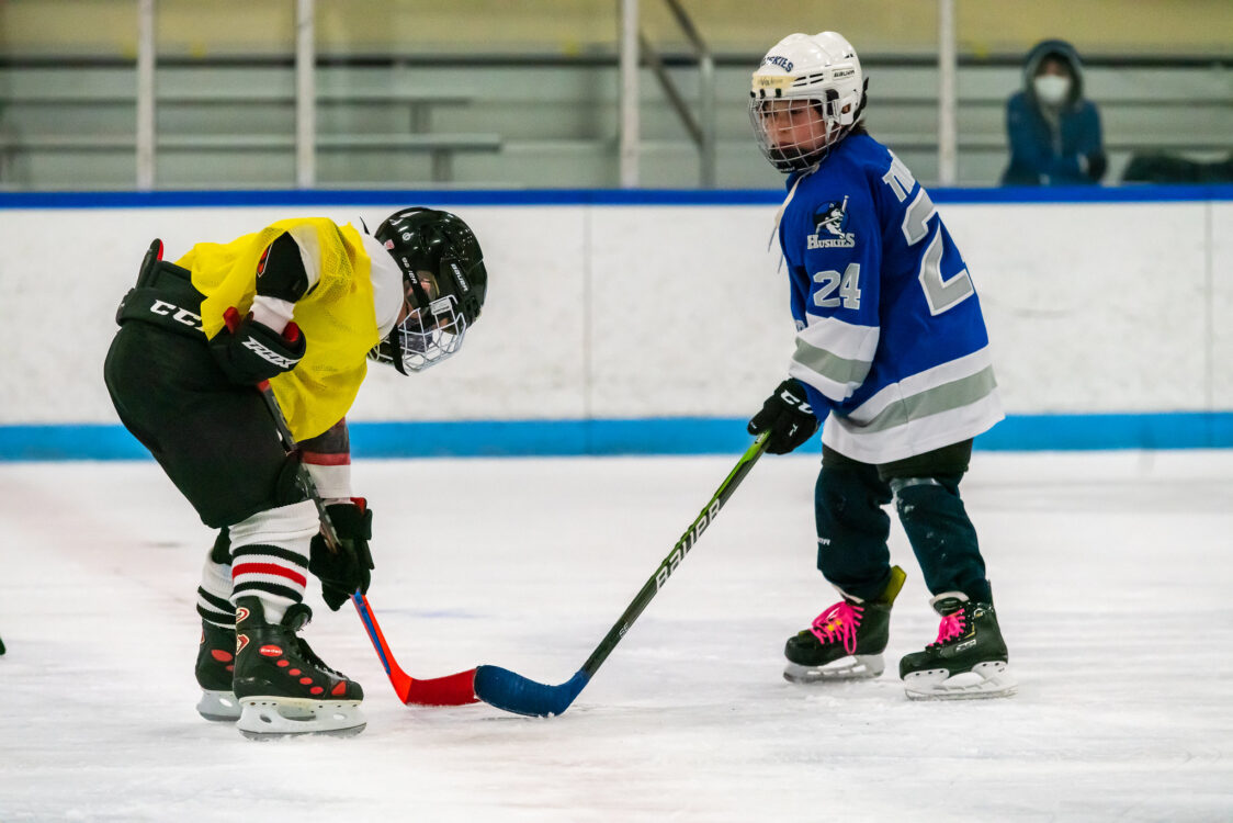 two kids at a face off at hockey camp