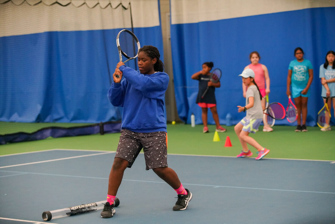 child practicing tennis volleys at tennis camps