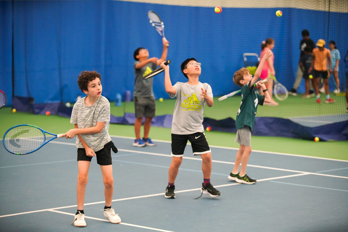 campers practicing their serve at summer camp