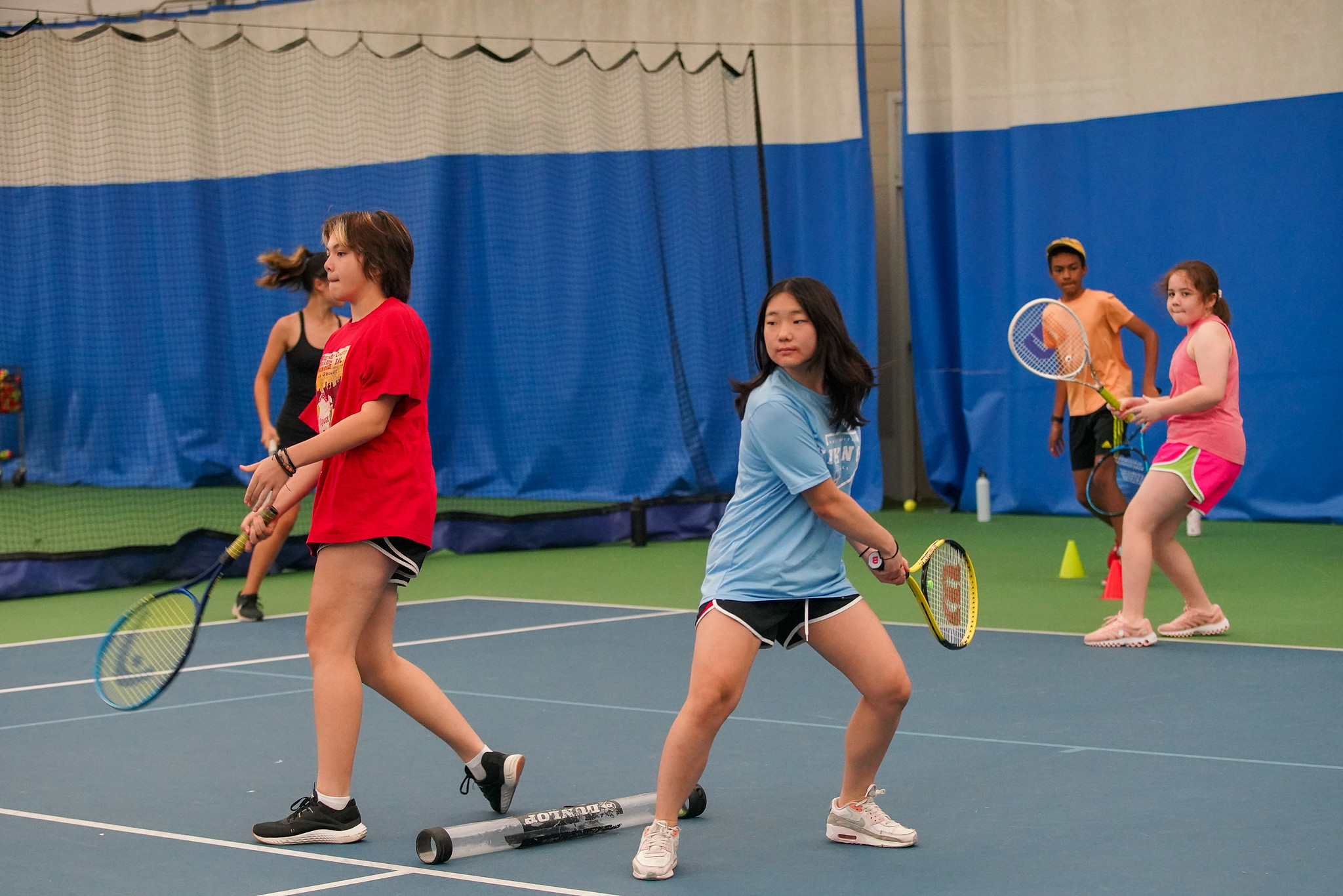 child hitting a tennis ball at tennis camp