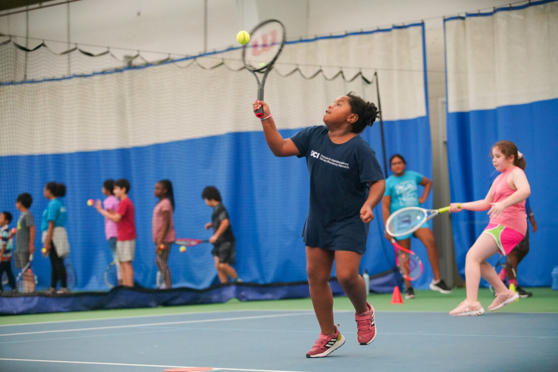 child hitting a tennis ball at tennis camp