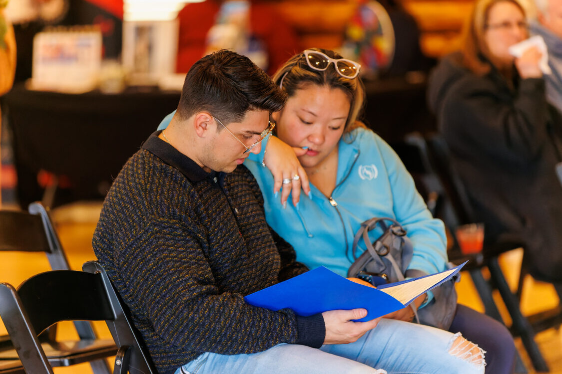 couple looking at supplier list Seneca Lodge Winter Open House