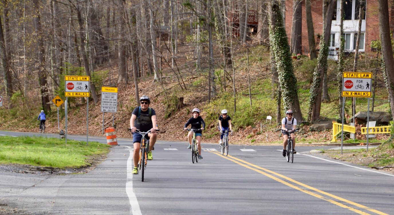 Four people—adults and children—ride bikes on Sligo Creek Parkway.