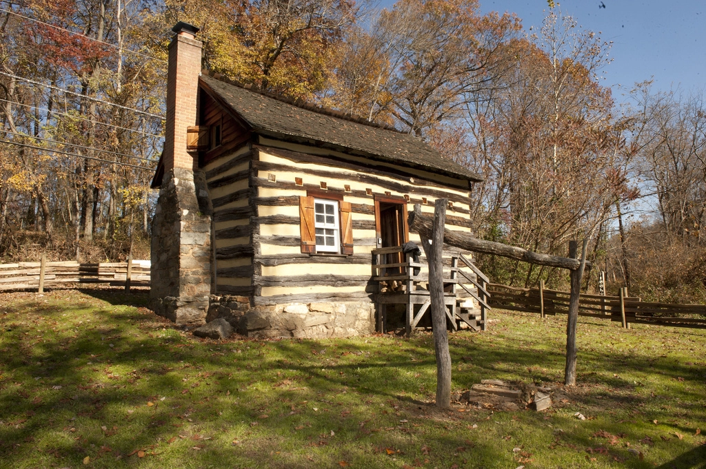 Log cabin surrounded by a wooden fence