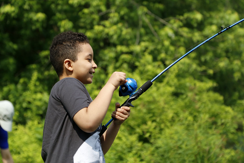 A kid smiling and fishing