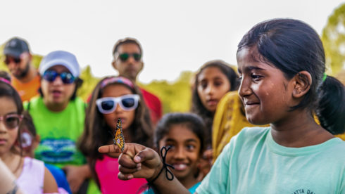 A girl with a butterfly on her finger