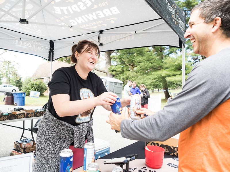 woman hands a man a beer