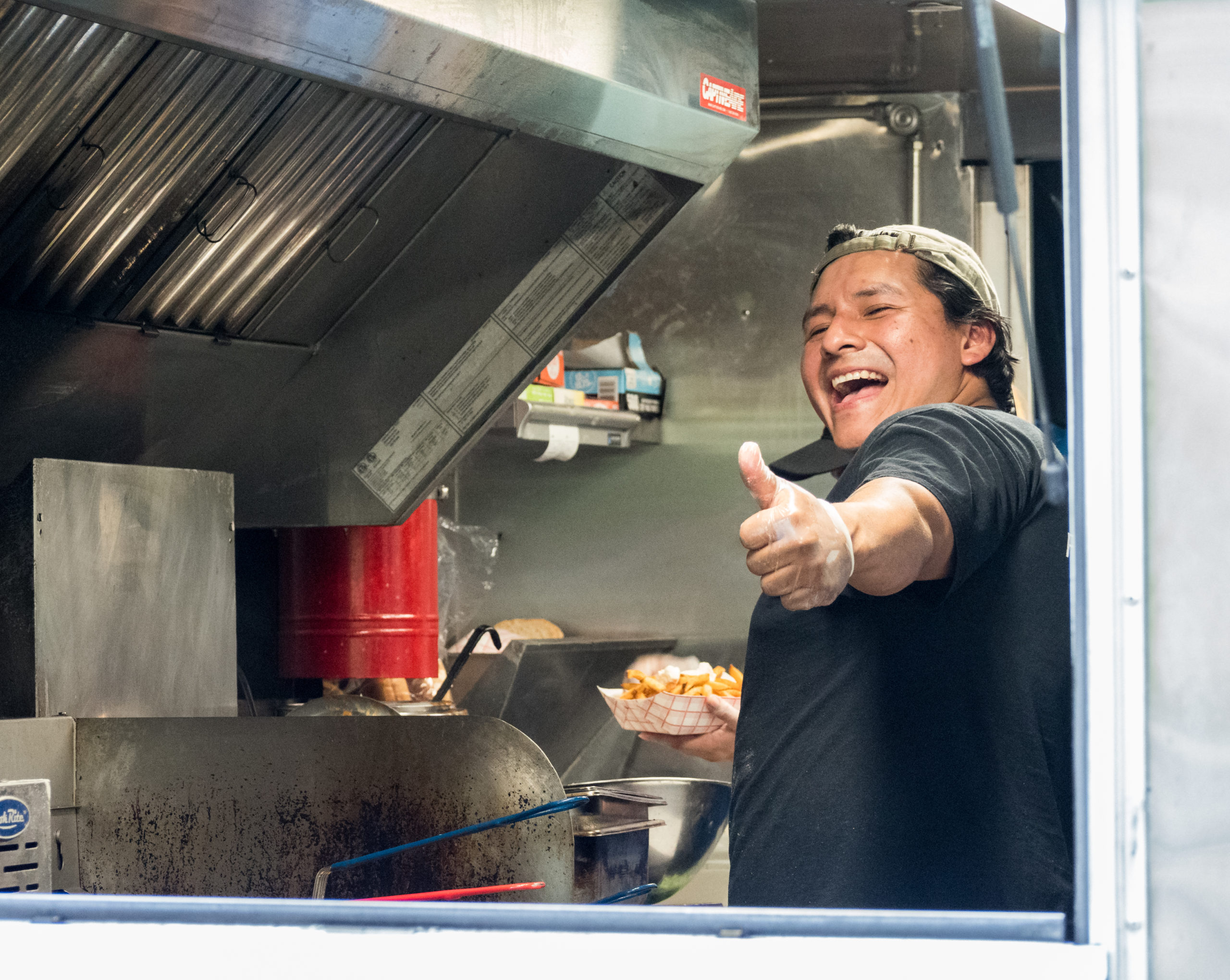 past acoustics and ales food vendor smiling for the camera and giving a thumbs up