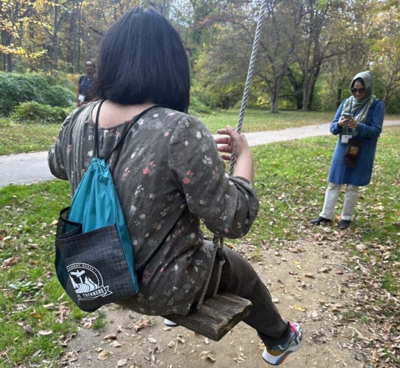 trail trekkers participant swinging on swing found along Little Falls Trail with mother taking her picture