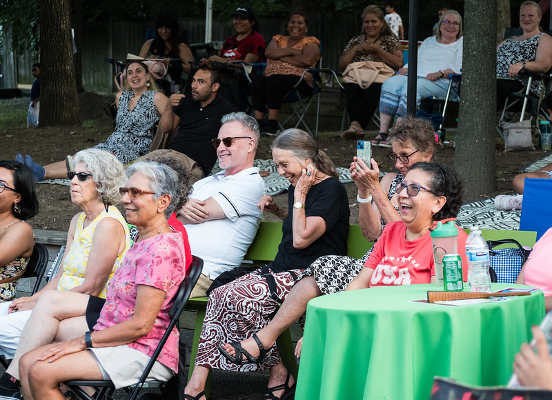 group of audience members facing stage and laughing