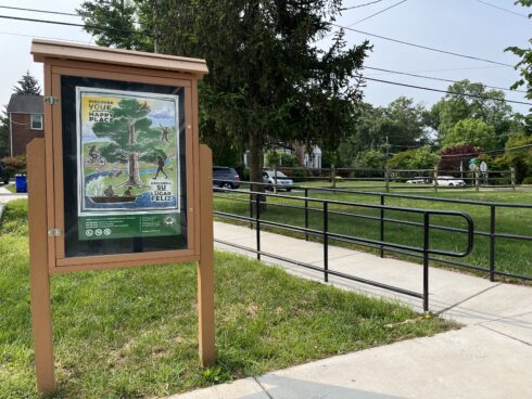 Kiosk in a park with poster stating "discover your happy place," 