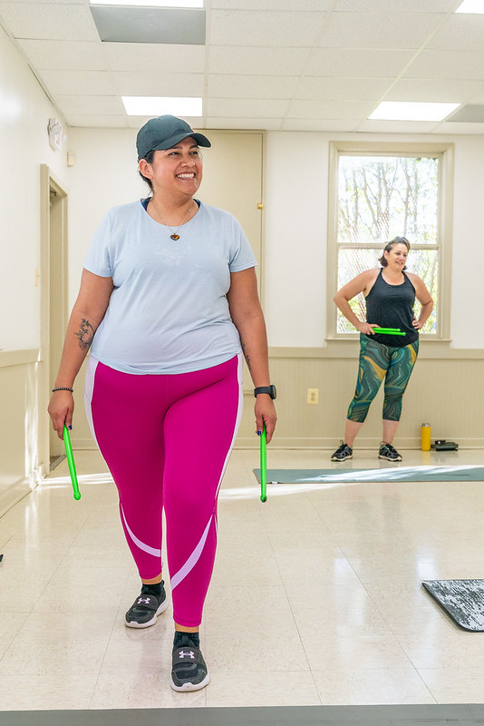 up close candid of pound fitness class member smiling toward instructor