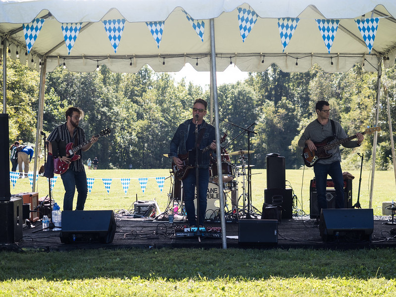 the band playing for a crowd at the ale trail event