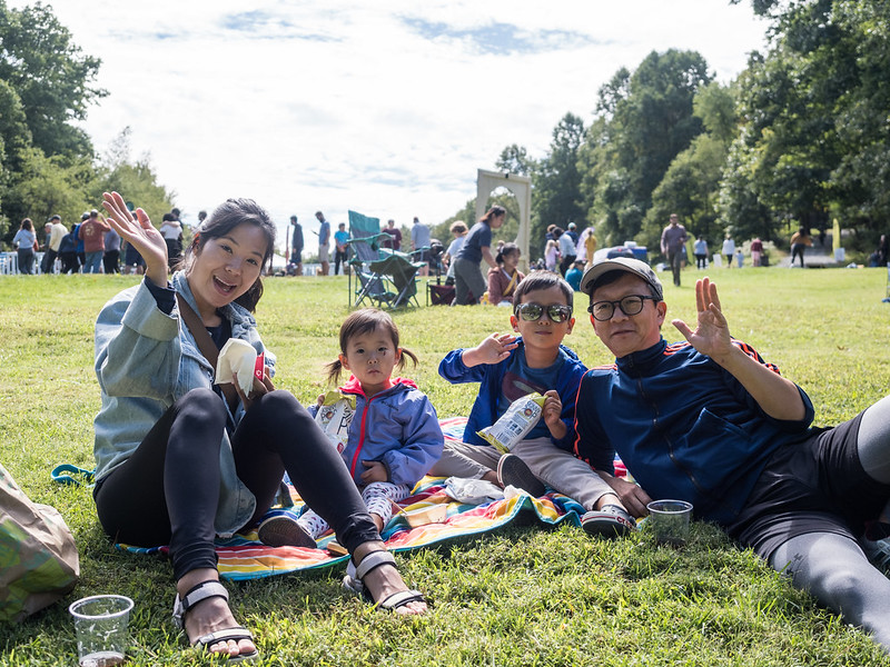 family sitting in the grass enjoying a nice day at the ale trail event