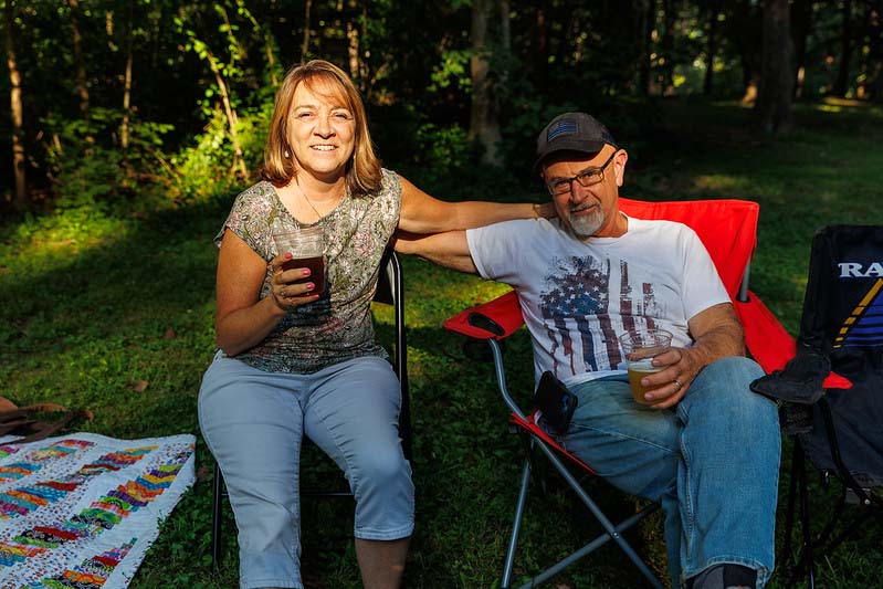 a couple sitting in camp chairs  at Montgomery parks summer concert