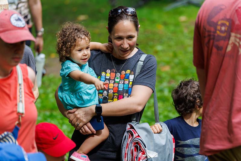 person holding a child at the Happenstance Theater production in summer of 2023