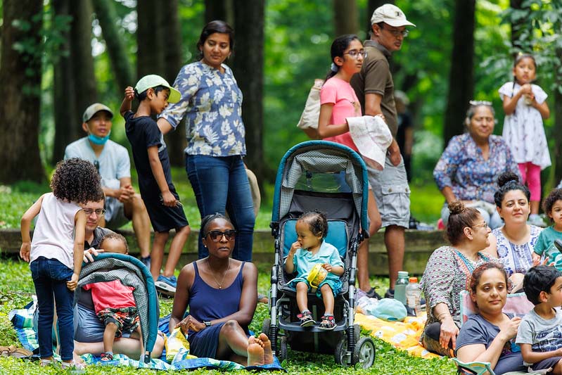 more families sitting and enjoying the Happenstance Theater production in summer of 2023